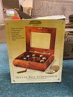 Box packaging showing product image and details about music box features and songs played.