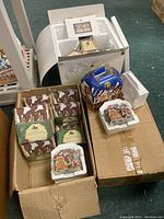 Three boxes containing Charles Dickens Heritage Village ornaments and a Season's Bay chapel by Dept 56 in original packaging.