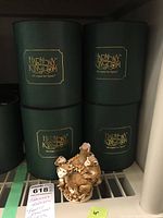 Eight original green Harmony Kingdom boxes stacked closely, with one monkey figurine displayed in front showing the detailed monkeys clustered