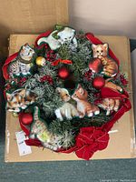 Top view of entire wreath showing kitten images, ornaments, red ribbon and greenery with frosted effect