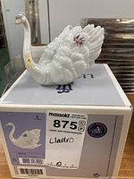 White swan figurine placed on original Lladro box with lot label showing model number 6499
