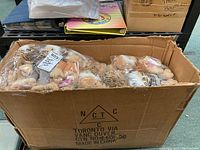 Cardboard box with multiple sealed plastic bags of plush monkeys