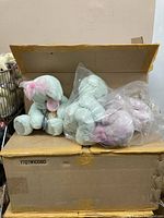 Two boxes containing multiple Precious Moments plush bears, some in plastic bags.
