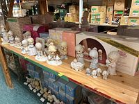 Shelf view of approximately 7 Precious Moments figurine sets, includes nativity scene and a clock, most with original boxes.