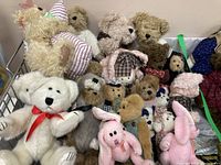 Wide view of the collection showing multiple Boyds Mohair bears and other stuffed animals including a large white bear with red bow and pink bunnies.