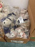 Box containing multiple Boyds Bears Bearwear plush teddy bears packed in plastic bags.