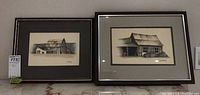 Two framed and signed original art pieces depicting barns, shown side by side with tags.