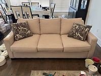 Front view of sofa with two throw pillows on hardwood floor