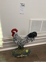 Front angle view of the cast iron rooster door stop showing painted details and base.