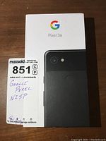 Front view of Google Pixel 3a box with phone image and Google logo, lot tag showing "Google Pixel N3P".