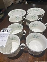 Tea cups arranged on table, showing floral pattern and silver trim