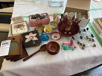 Full overview of table accessories including coasters, bowls, flatware rests, nut dishes, and a wooden bird toothpick holder.