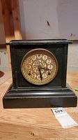 Front view of Leno antique mantel clock showing ornate dial and black rectangular case.