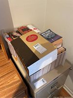 Overview photo of plastic bins filled with various books including a thick hardcover volume and several paperbacks visible on top.
