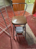 Photo of vintage chair stool showing brown padded seat and chrome metal frame with triangular wire design backrest