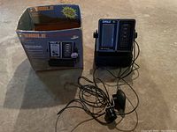 Eagle Z6100 fish finder device with original box and attached transducer with cable, all displayed on floor surface.