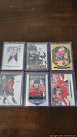 Six hockey cards featuring Alex Ovechkin in protective sleeves arranged on table.