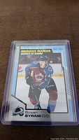Hockey trading card showing Bowen Byram in Colorado Avalanche jersey labeled 'Marquee Rookies'. Card encased in protective sleeve and plastic holder.
