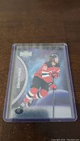 Photo of Dawson Mercer rookie hockey card in protective plastic case, showing player in New Jersey Devils uniform number 18.