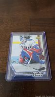 Henrik Lundqvist rookie hockey card featuring the player in New York Rangers goaltender gear, encased in plastic protective sleeve.