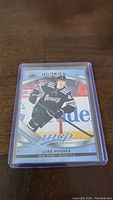 Photo of Luke Hughes rookie hockey card showing front of card in protective sleeve.