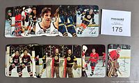 Array of 25 glossy hockey cards laid out horizontally and vertically, showing player images and partial autographs. Cards feature goaltenders and skaters from NHL teams.