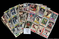 Spread of hockey cards displayed on table inside plastic binder pages. Multiple players visible including Wayne Gretzky, Bobby Orr, Guy Lafleur.