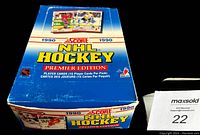 Top view photo of partially opened box with visible box wear and unopened packs inside.