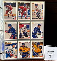 Nine hockey cards in binder page, showcasing players from the 1991-92 Upper Deck set, including various teams and positions.