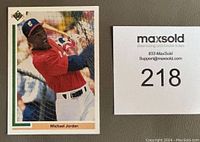 Front of 1991 Upper Deck Michael Jordan rookie baseball card with Michael Jordan batting in white pants and red shirt.