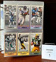 Photo of binder page showing football cards of Troy Aikman, Terry Allen, Ray Childress, Marco Coleman, Barry Foster, Sterling Sharpe