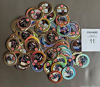 Lot of 75 Wayne Gretzky POGs spread in a pile showing variety of colors and images