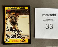 Front of the 1991-92 Score Bobby Orr hockey card with Bobby Orr in playing action, featuring autograph and personalization 'To John Bobby Orr' in black Sharpie.
