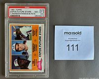 Photo of 1981 Topps Expos Future Stars baseball card graded PSA 8 NM-MT, featuring Tim Raines Rookie card along with Roberto Ramos and Bobby Pate, in protective plastic case with grading label visible.