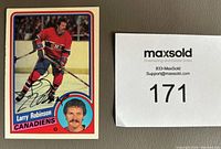 Front of the 1984-85 O-Pee-Chee Larry Robinson hockey card signed in black Sharpie.