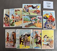 Set of 18 vintage French risqué postcards with colorful illustrations, arranged on brown surface showing varied scenes of playful women and men.