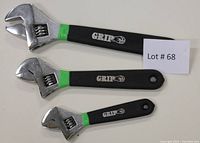 Photo showing three GRIP adjustable wrenches arranged vertically with lot number card, highlighting size differences and handle branding.