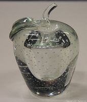 Front view of clear glass apple with internal bubbles and curved stem.