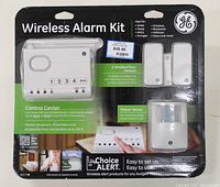 Front view of sealed packaging showing control center, window/door sensors and motion sensor clearly visible with descriptive text and GE branding.