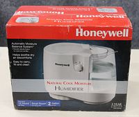 Front of the Honeywell humidifier box showing the humidifier image, brand, and product features including moisture balance system, 2 gallon capacity, and 12 hour runtime.