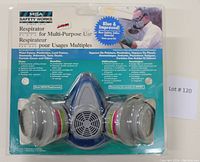 Front view of MSA Safety Works respirator in sealed packaging showing dual cartridge filters, blue mask body, and product branding.
