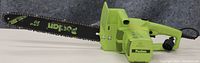 Side view of electric chainsaw showing green body, black 16-inch bar with Poulan branding