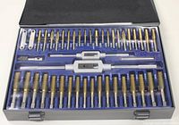 Open metal case revealing organized tap and die set with 86 pieces including taps, dies, tap wrenches and other threading tools.