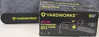 Photo of Yardworks 9 amp electric chainsaw with its original box, showing the chainsaw bar and box details.