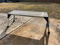 Aluminum platform scaffolding set up outdoors showing the full platform and legs.