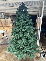 Full view of the 7.5-foot artificial Christmas tree set up outdoors under a roof.