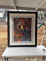 Full view of the large framed artwork showing abstract bear holding a bird with vibrant colors.