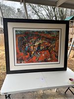 Full view of the large framed buffalo artwork on a table outside.