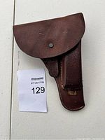 Front view of brown leather holster with snap button flap.