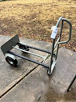 Side view of the metal handtruck on concrete with the load plate and wheels visible